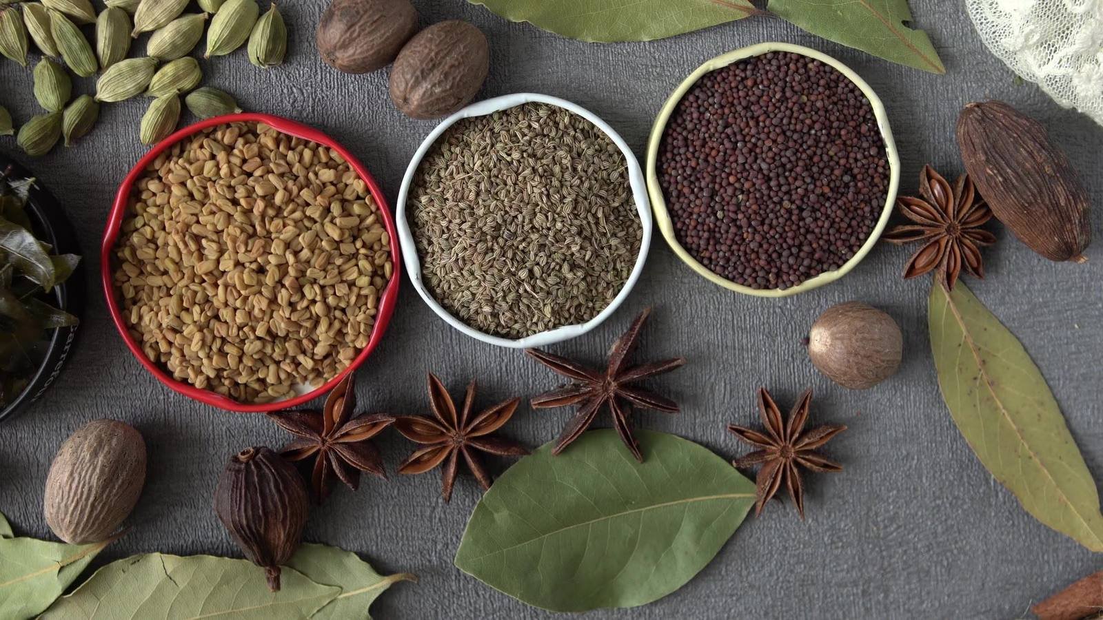 Bowls of Indian spices cumin, mustard seeds, star anise and cardamom