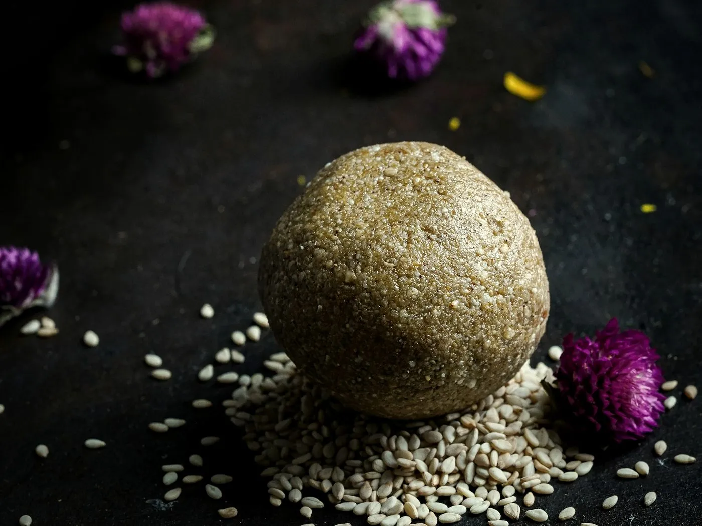 Hulled white sesame seeds on a wooden spoon